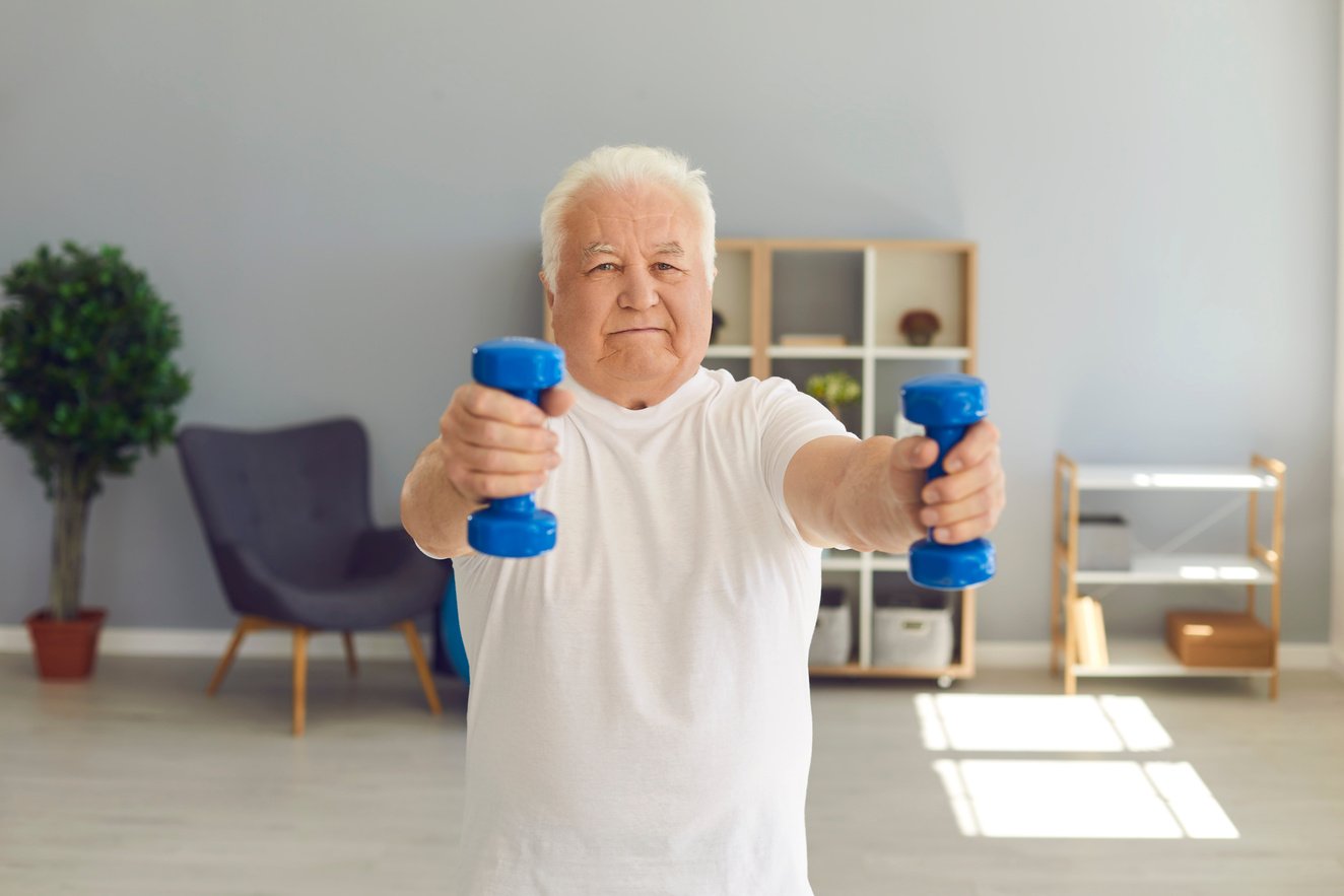 Senior Man Leading Active Lifestyle Exercising with Dumbbells in His Living-Room